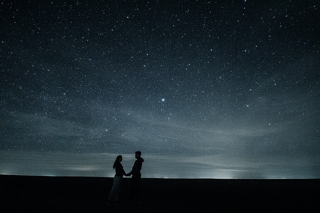 Couple holding hands under the stars.