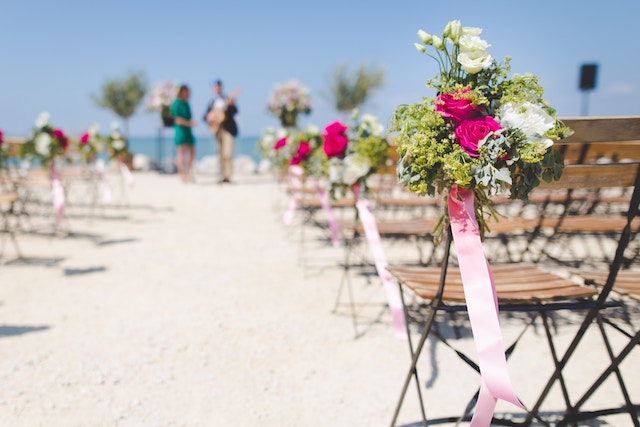 Flowers and chairs set up for a beach wedding.