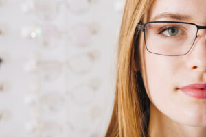 half of the face of a woman with glasses.