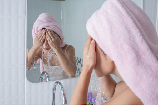 woman washing her face as skincare regime.