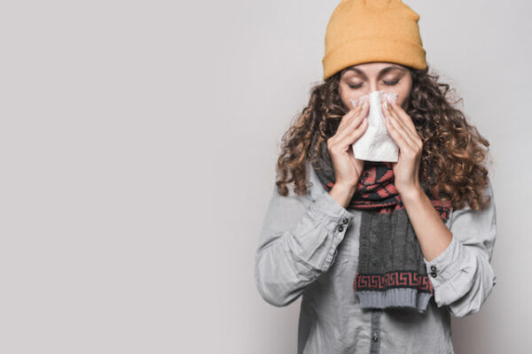 woman sneezing with a sinus infection.