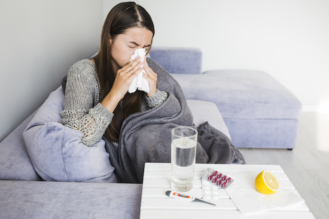 woman sneezing with different home remedies for her sinus infection.