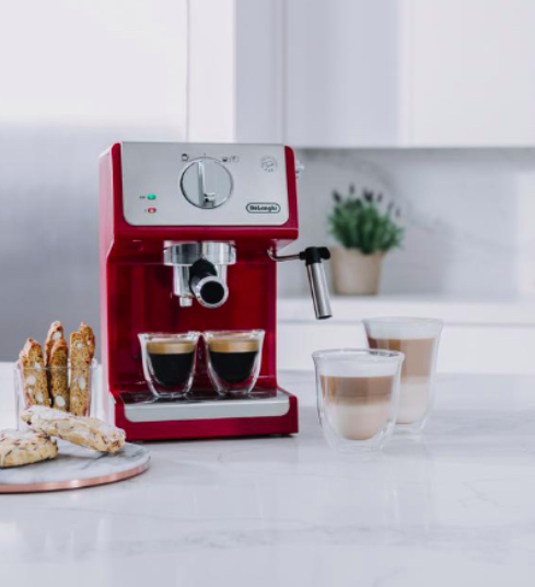 a coffeemaker with ready made coffee and biscuits in a kitchen.