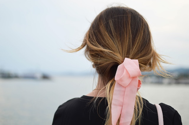 pink bow in a woman's hair.